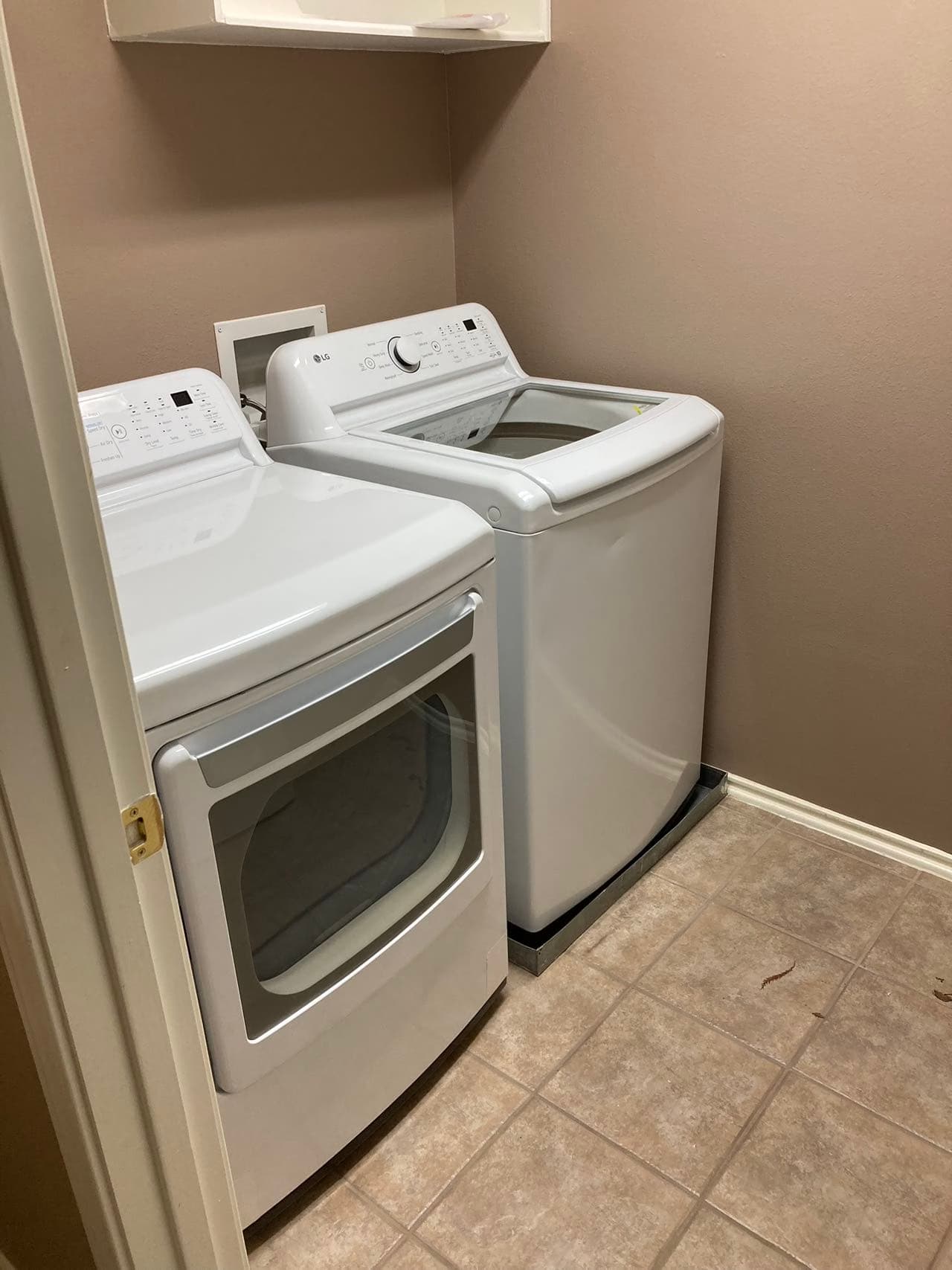 White washer and dryer pair installed side by side in a laundry closet